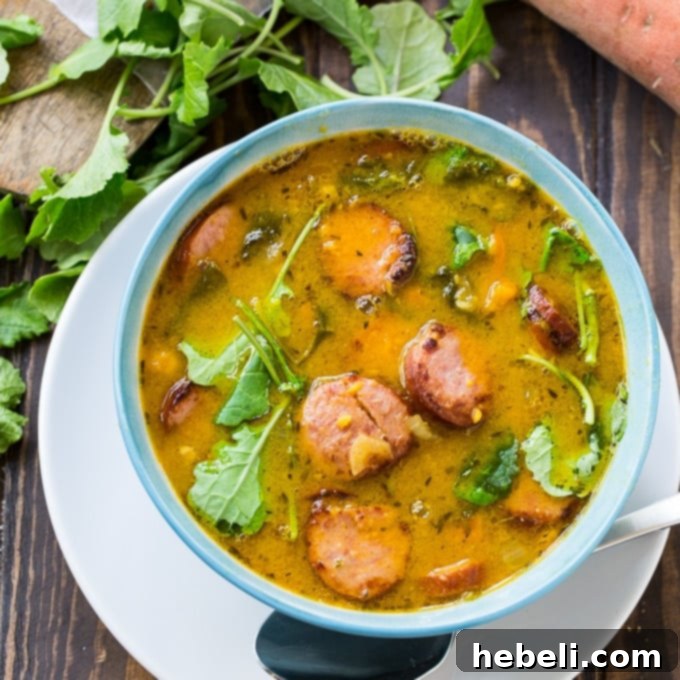 Hearty Sausage and Sweet Potato Soup, garnished with fresh herbs, in a rustic bowl.