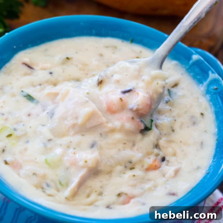 Creamy Leftover Turkey Wild Rice Soup, garnished with fresh herbs, in a rustic bowl.