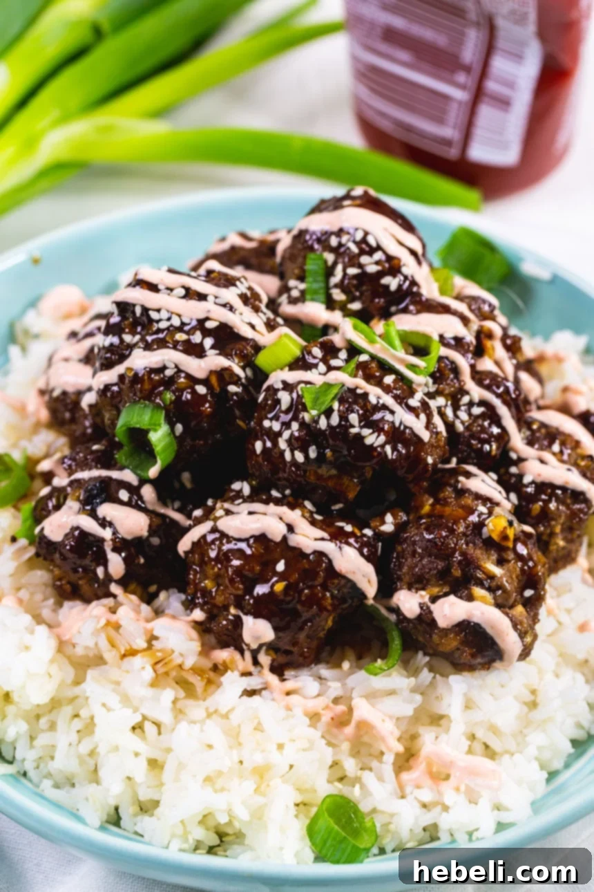 Effortless Korean Bulgogi Meatballs 4 A generous pile of freshly cooked Beef Bulgogi Meatballs resting on a bed of fluffy white rice, ready to be served.
