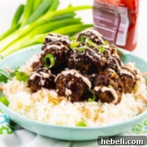 Meatballs over rice in a light blue bowl.