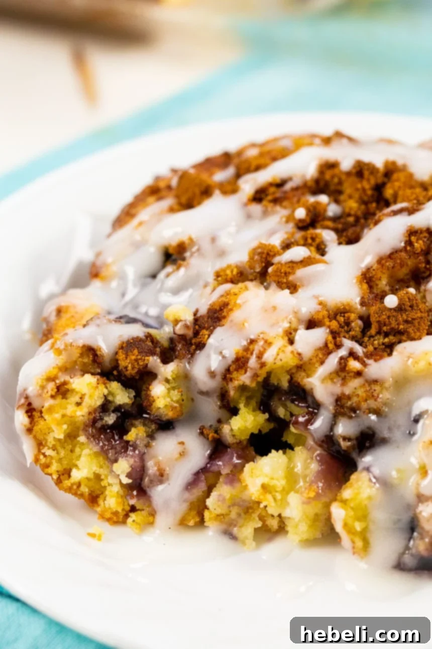 Blueberry Pie Coffee Cake Perfection 4 Close-up of a glazed slice of Blueberry Coffee Cake, highlighting the rich texture, vibrant blueberry filling, and sweet topping with a golden-brown crust.