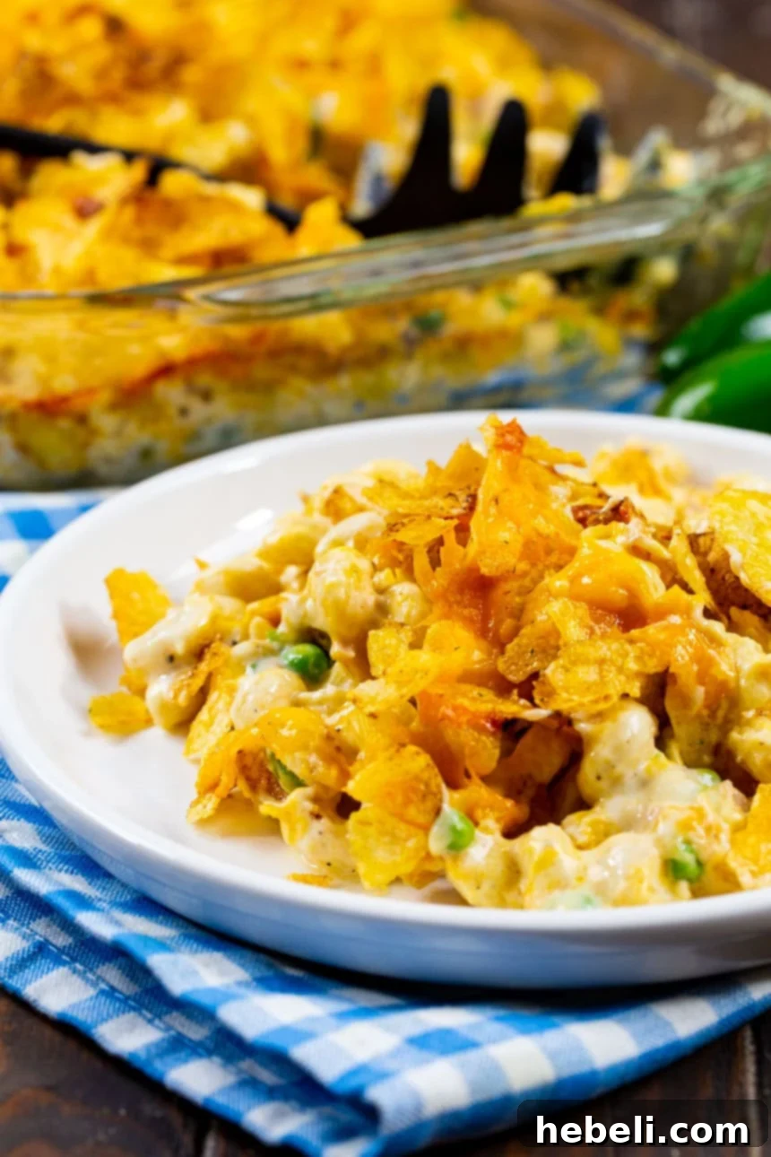 A portion of Jalapeño Tuna Noodle Casserole served on a white plate, showing the creamy texture and crispy topping.