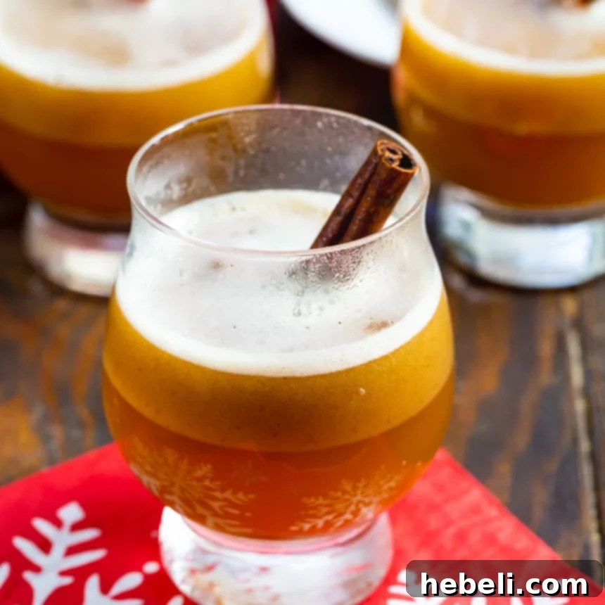 Hot Buttered Bourbon in a glass with a cinnamon stick, evoking a cozy winter evening.