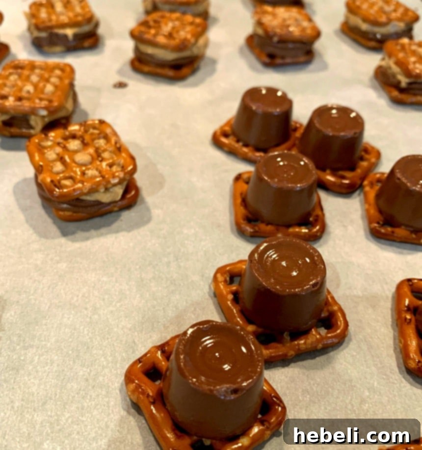 Sweet and Salty Rolo Pretzel Bites 4 Close-up shot of Rolo candies strategically placed on top of square pretzels on a baking sheet, ready for the oven.