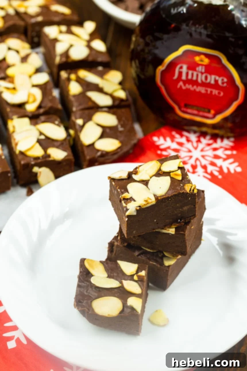 Three perfectly cut pieces of Chocolate Amaretto Fudge arranged elegantly on a plate.