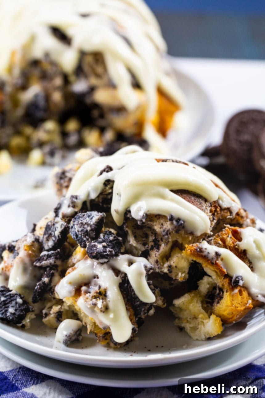 A single piece of Cookies and Cream Monkey Bread on a white plate, showcasing its rich texture and generous glaze.