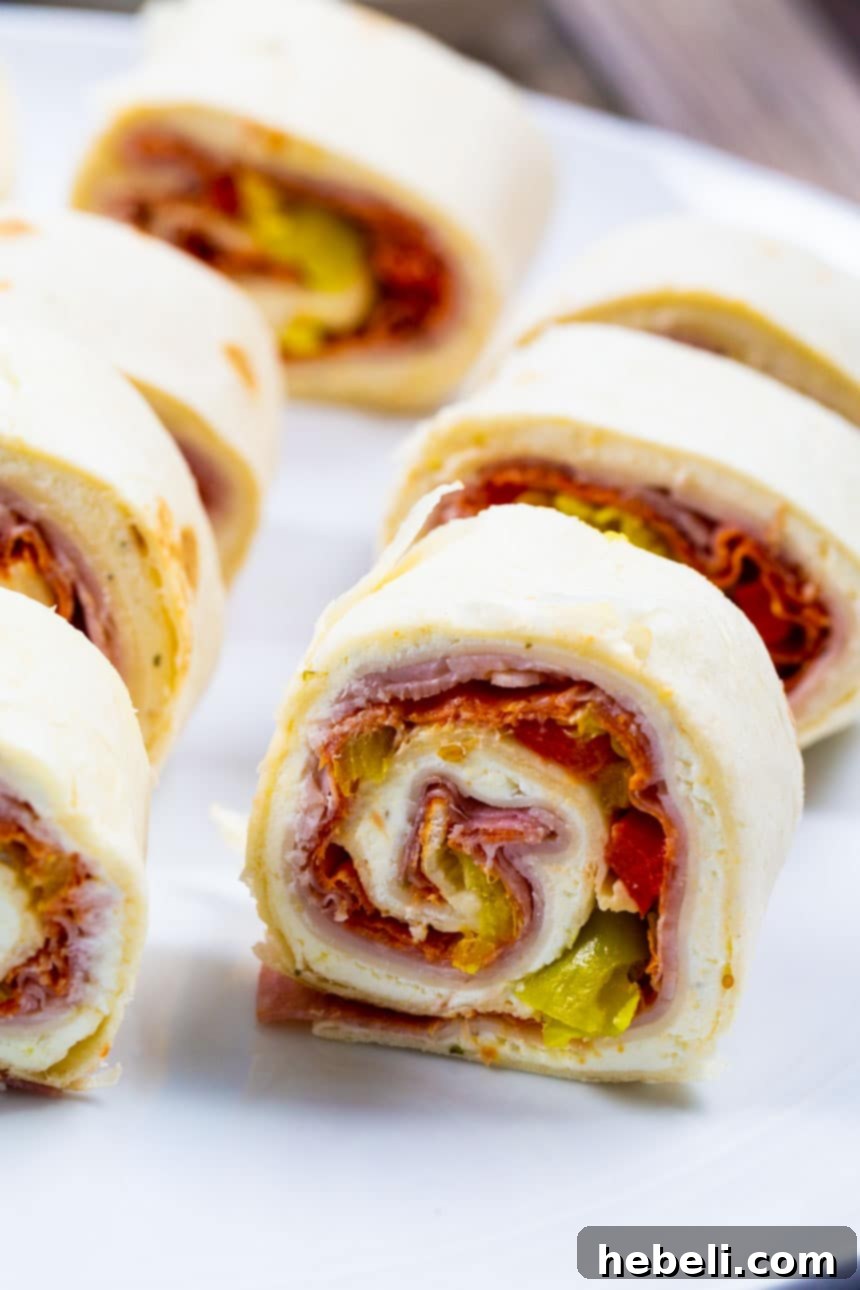 Zesty Italian Swirls 4 Close-up of a perfectly rolled Spicy Italian Pinwheel, showcasing the delicious filling before slicing.