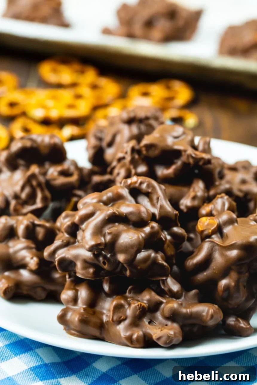 Sweet and Salty Chocolate Pretzel Bites 4 A stunning stack of Chocolate Peanut Clusters with Pretzels presented elegantly on a plate, highlighting their visual appeal and deliciousness.