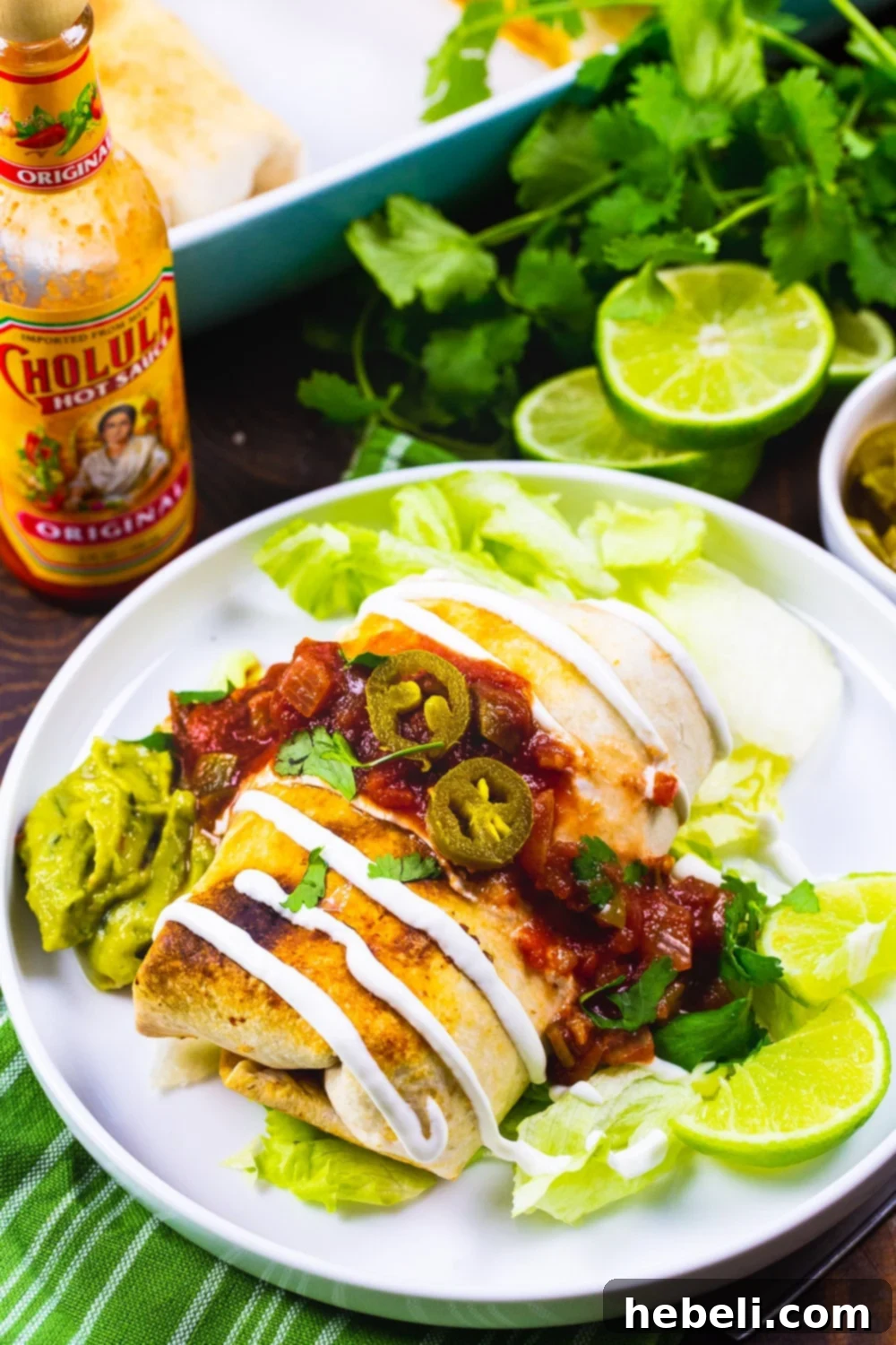 Crispy Baked Chicken Chimichangas 3 Plated Baked Chicken Chimichangas with a side of sour cream, salsa, and cilantro.