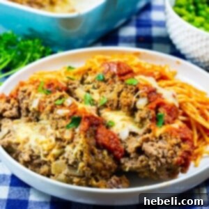 Two slices of Mozzarella Stuffed Meatloaf on plate with pasta.