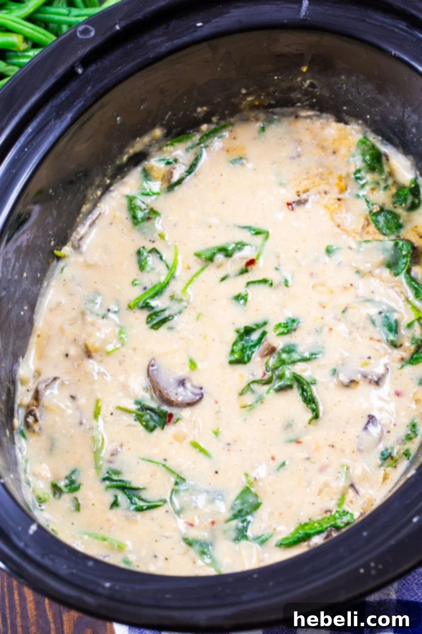 Garlic Parmesan Chicken simmering in a slow cooker, showcasing the creamy sauce and tender ingredients.