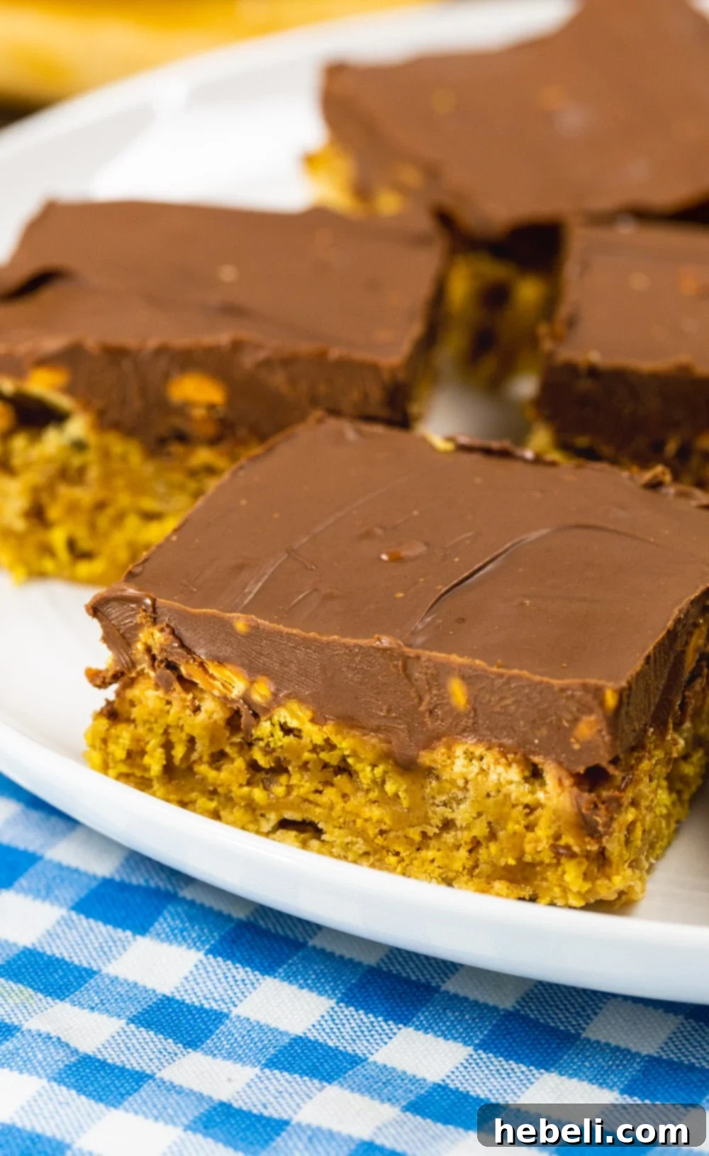 A close-up shot of a single Chex Scotcharoo bar, highlighting the thick, glossy chocolate and butterscotch topping.