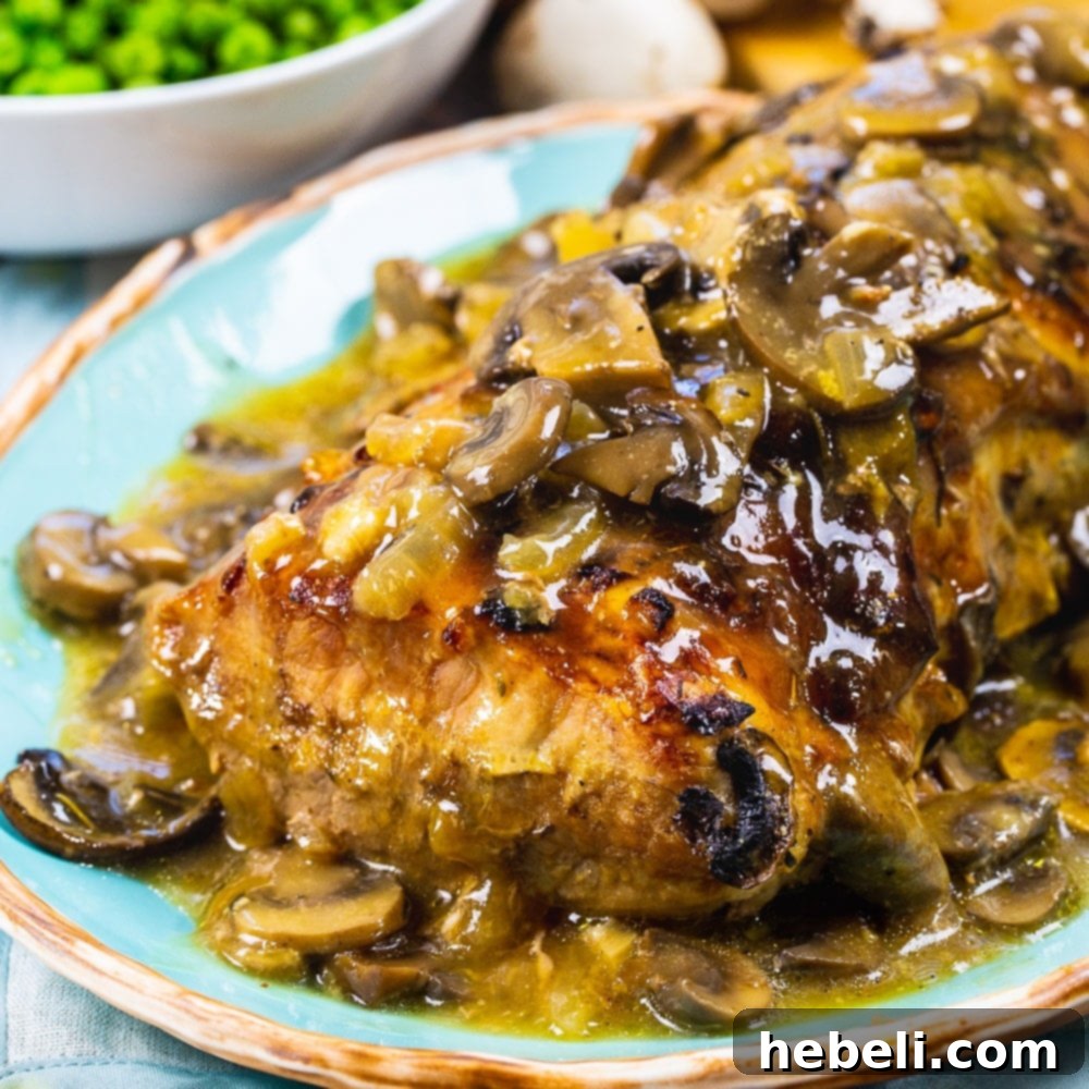 Succulent Roasted Pork Loin with Creamy Mushroom Gravy on a elegant serving platter, garnished, ready to be carved and enjoyed.
