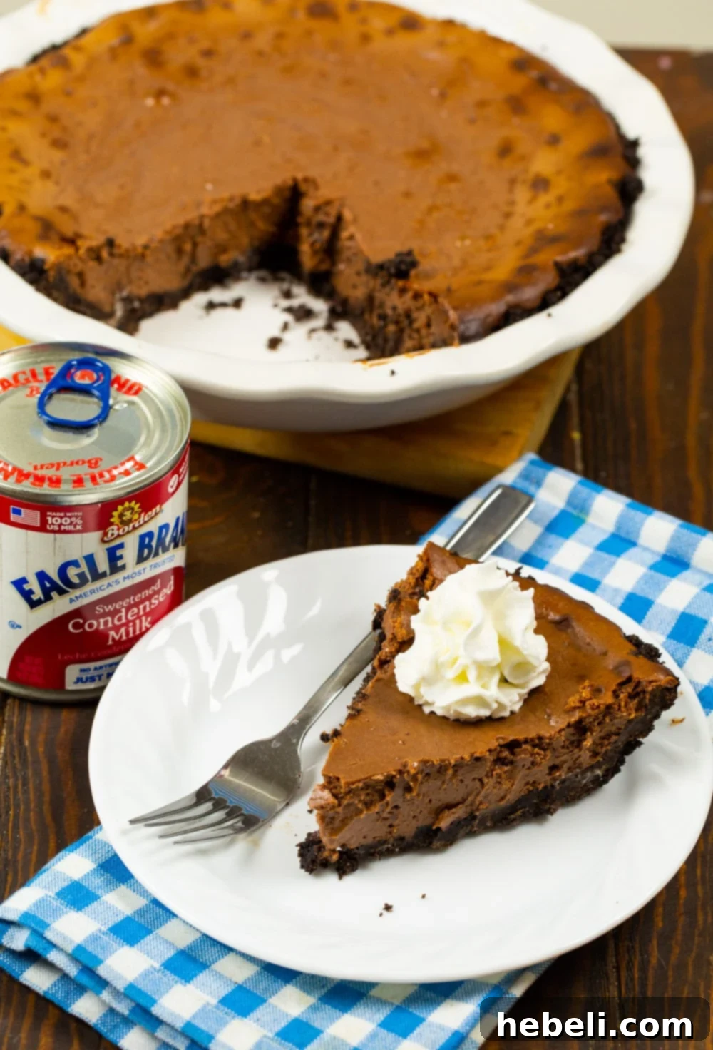 Velvety Chocolate Dream Pie 3 A delicious slice of Sweetened Condensed Milk Chocolate Pie presented on a white plate, with the rest of the pie visible in the background.