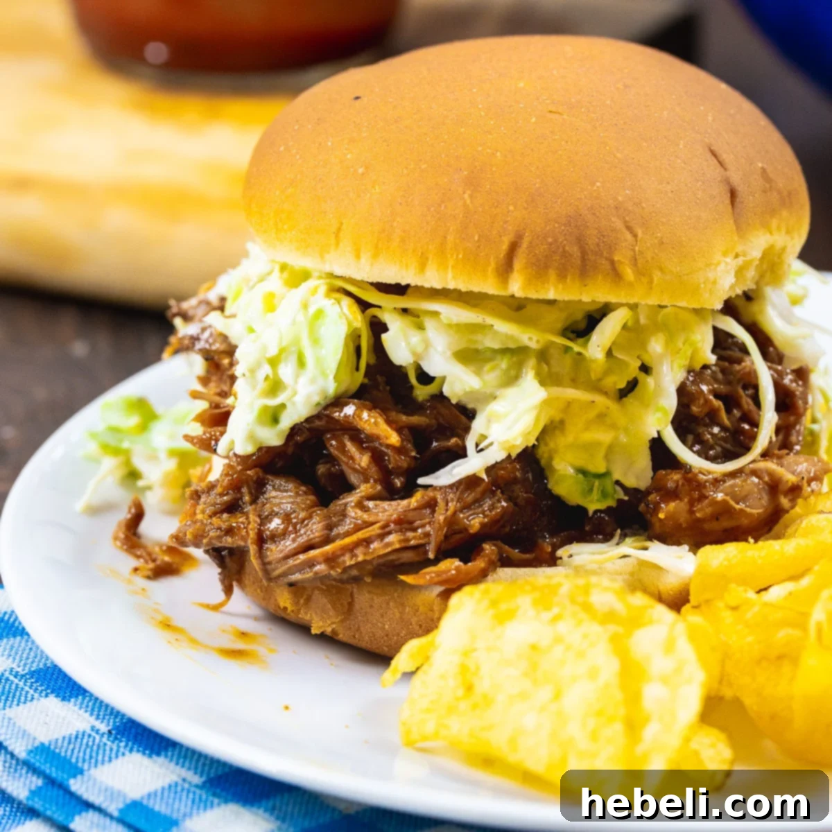 A delicious pulled pork sandwich served with a side of creamy coleslaw, showcasing the tender, shredded meat on a soft bun.