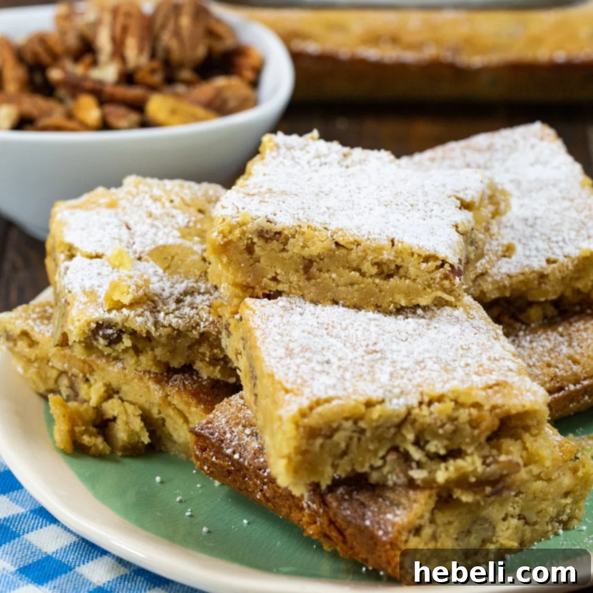 Charleston Chewies piled on a plate next to a bowl of pecans, showcasing their golden-brown color and nutty texture.