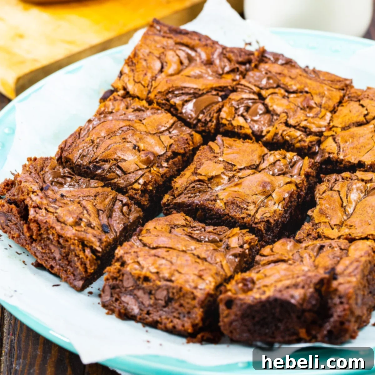 Nutella Brownies cut into perfect squares on a white plate, showcasing their rich, fudgy texture and shiny tops.