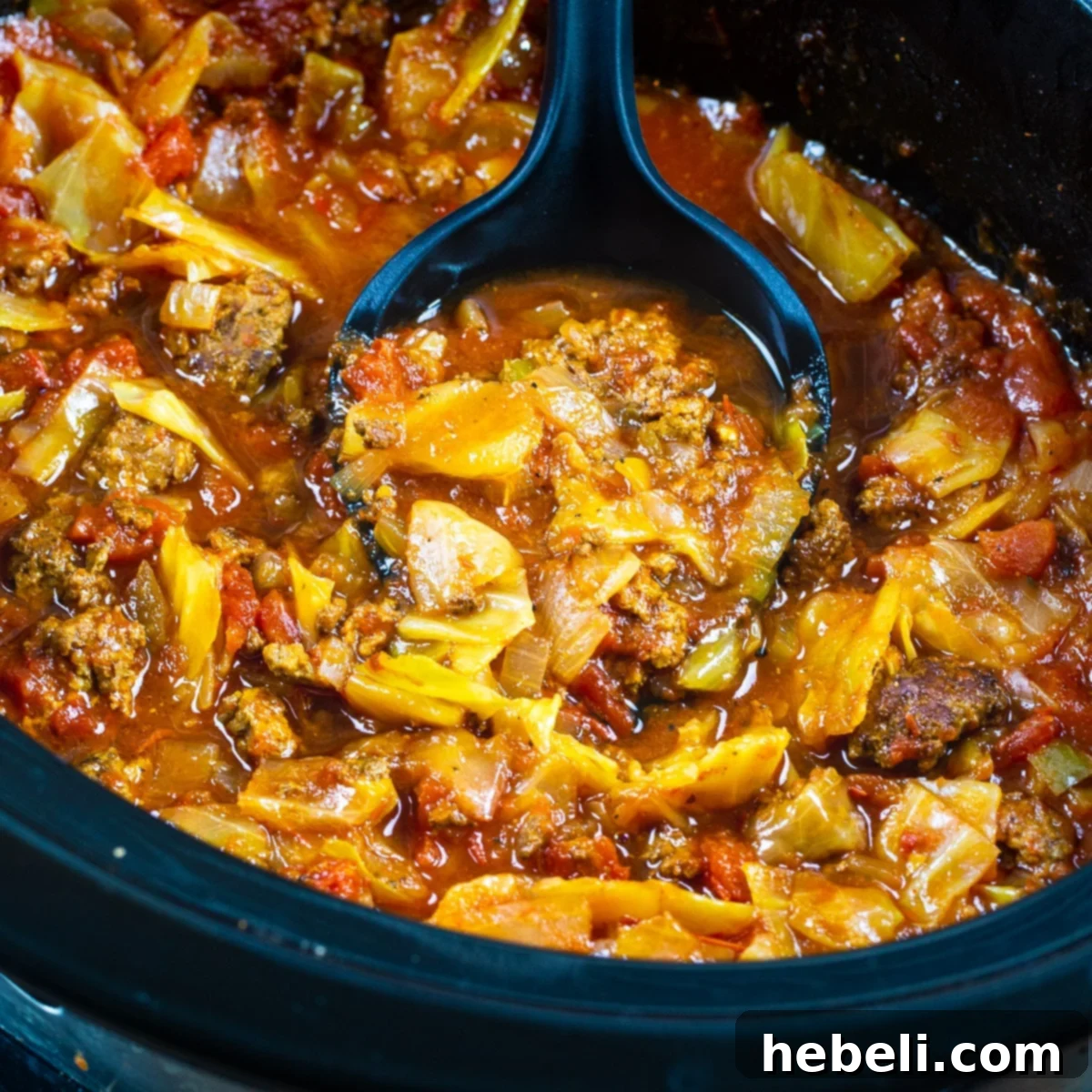 A large, rustic slow cooker filled with steaming Slow Cooker Spicy Cabbage Beef Soup, showcasing the tender cabbage and rich beef broth. Perfect for a cozy meal.