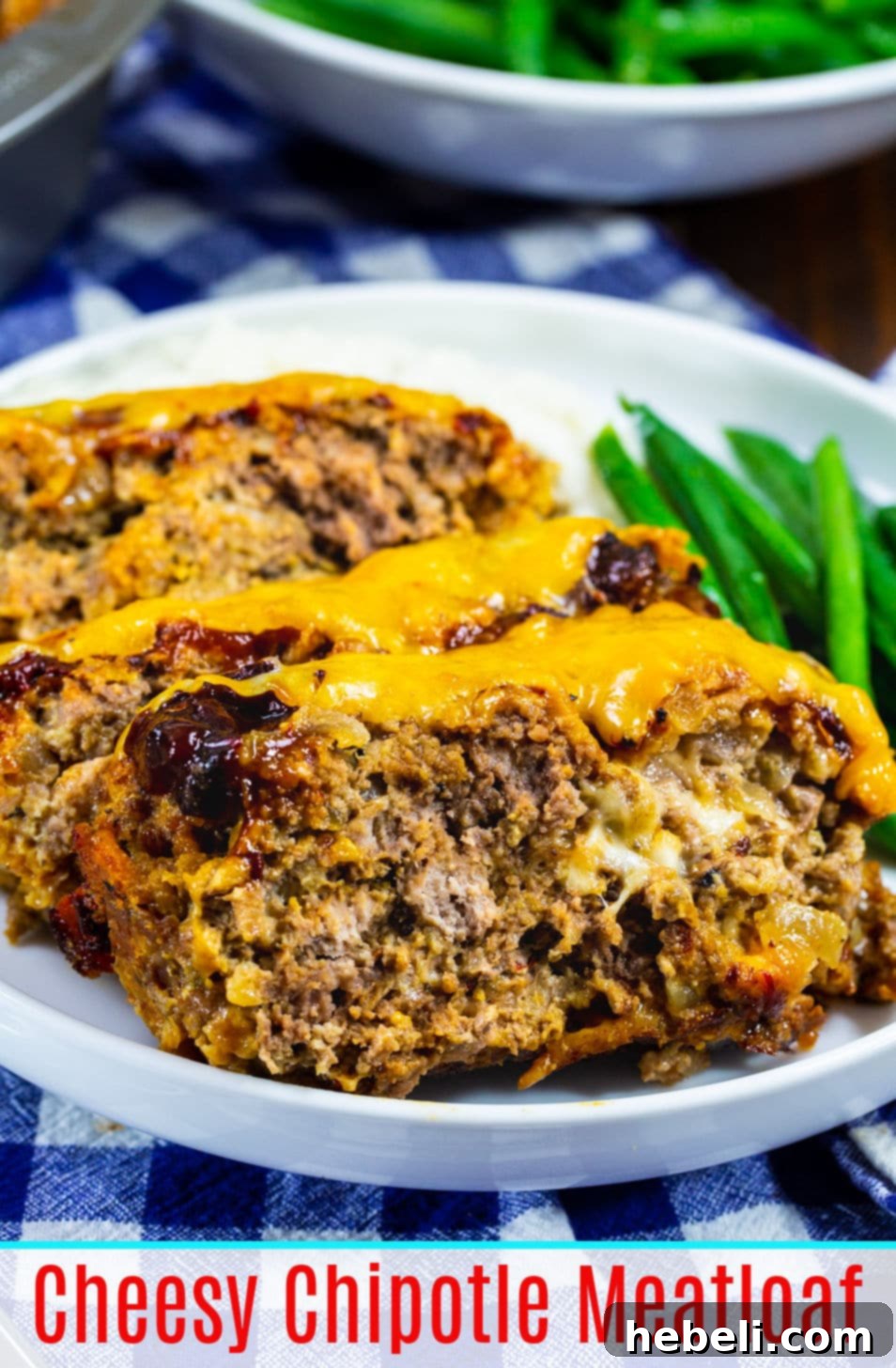 Gooey Cheesy Chipotle Meatloaf 6 Close-up of a slice of Cheesy Chipotle Meatloaf, showing the texture of the meat, melted cheese pockets, and the glossy glaze, emphasizing its rich and inviting appearance.
