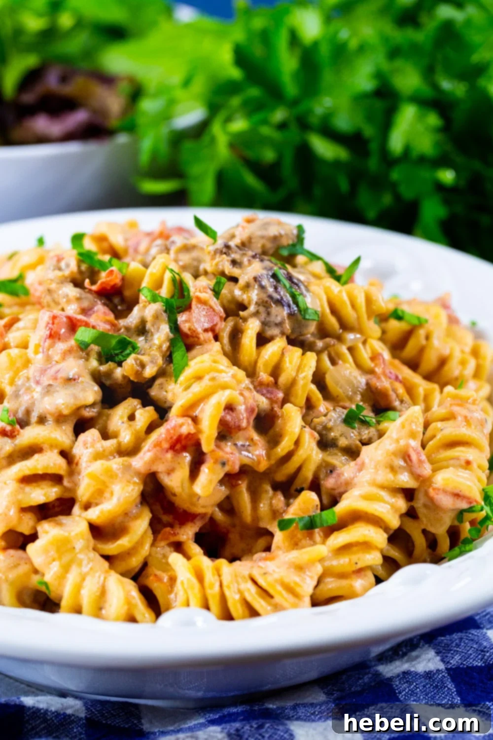 A large serving bowl filled with Creamy Rotel Pasta with Sausage, ready to be served.