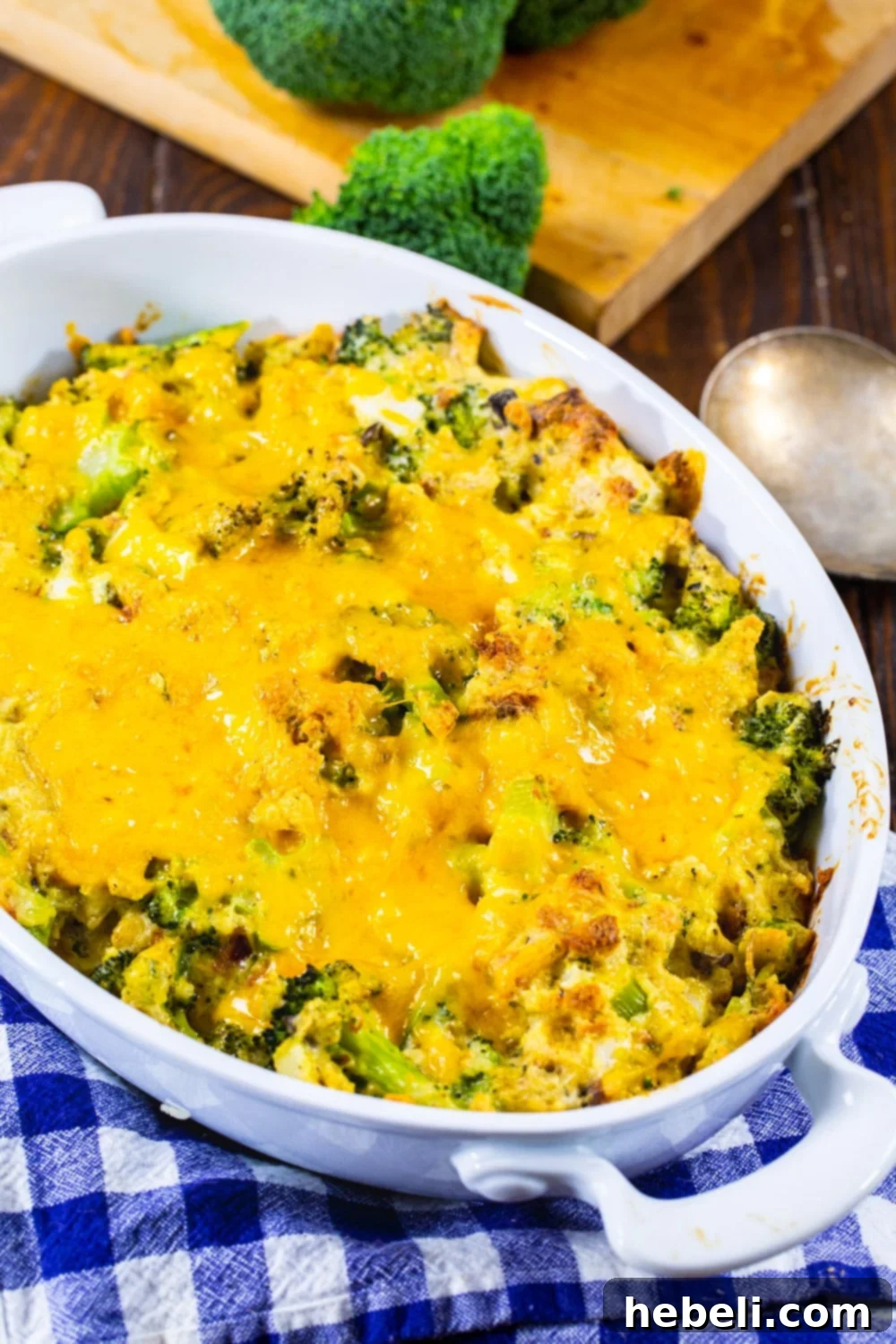 Close-up of the unbaked broccoli casserole mixture in a white dish, showing fresh broccoli florets, creamy sauce, and stuffing pieces.