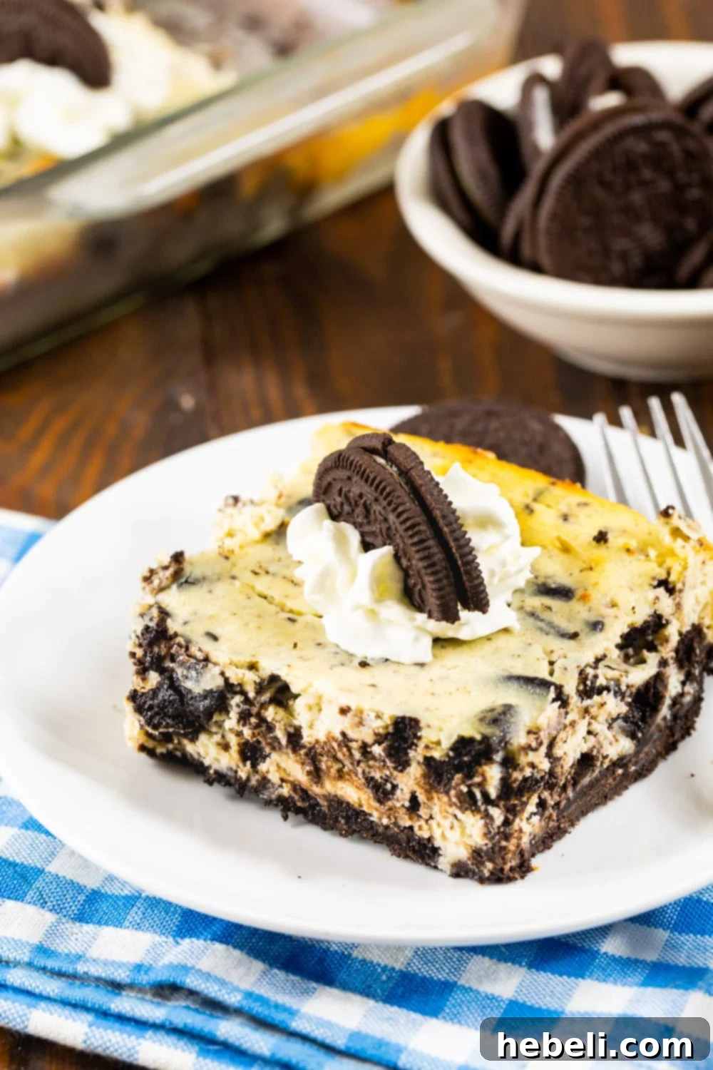 A slice of Oreo Cheesecake Bar served elegantly on a white plate, highlighting its distinct layers.