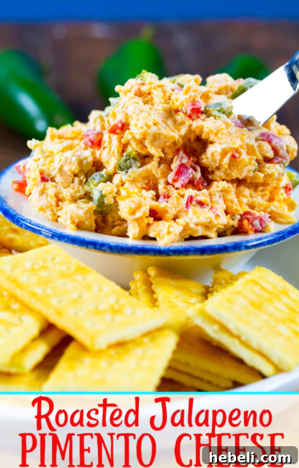 A curated display of fresh, high-quality ingredients laid out on a rustic wooden cutting board, including vibrant green jalapeno peppers, solid blocks of sharp cheddar and Monterey Jack cheese, a jar of diced pimentos, and a bowl of creamy mayonnaise, all prepped for making the ultimate pimento cheese.