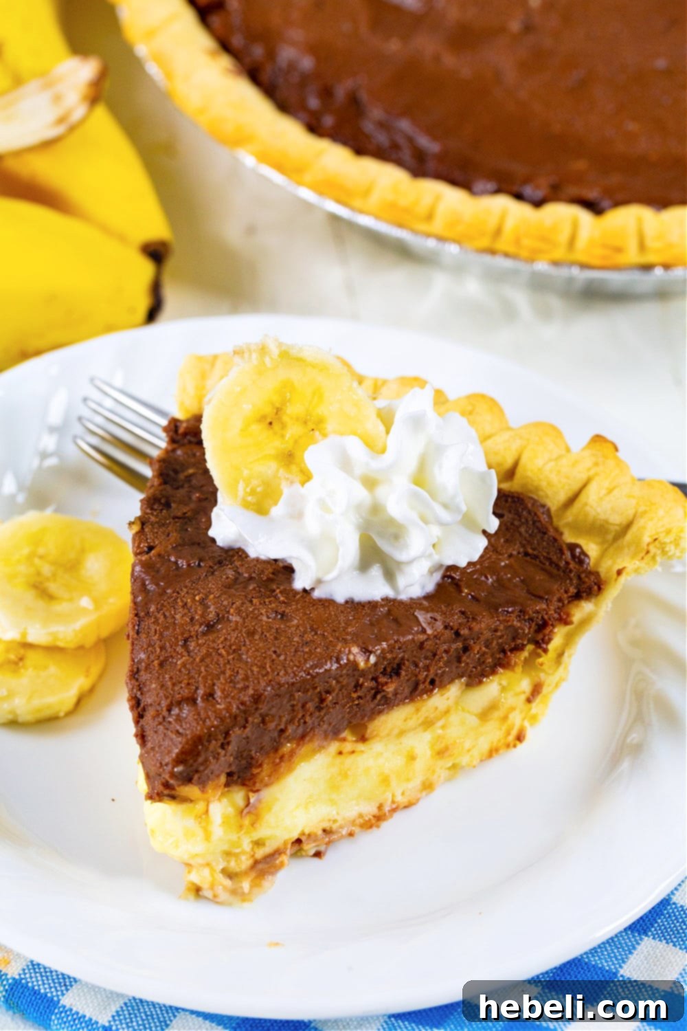 Creamy Chocolate Banana Bliss 7 An overhead shot of a whole Chocolate Banana Cream Pie, beautifully presented before slicing, with a hint of whipped cream on top and a smooth, glossy chocolate layer.