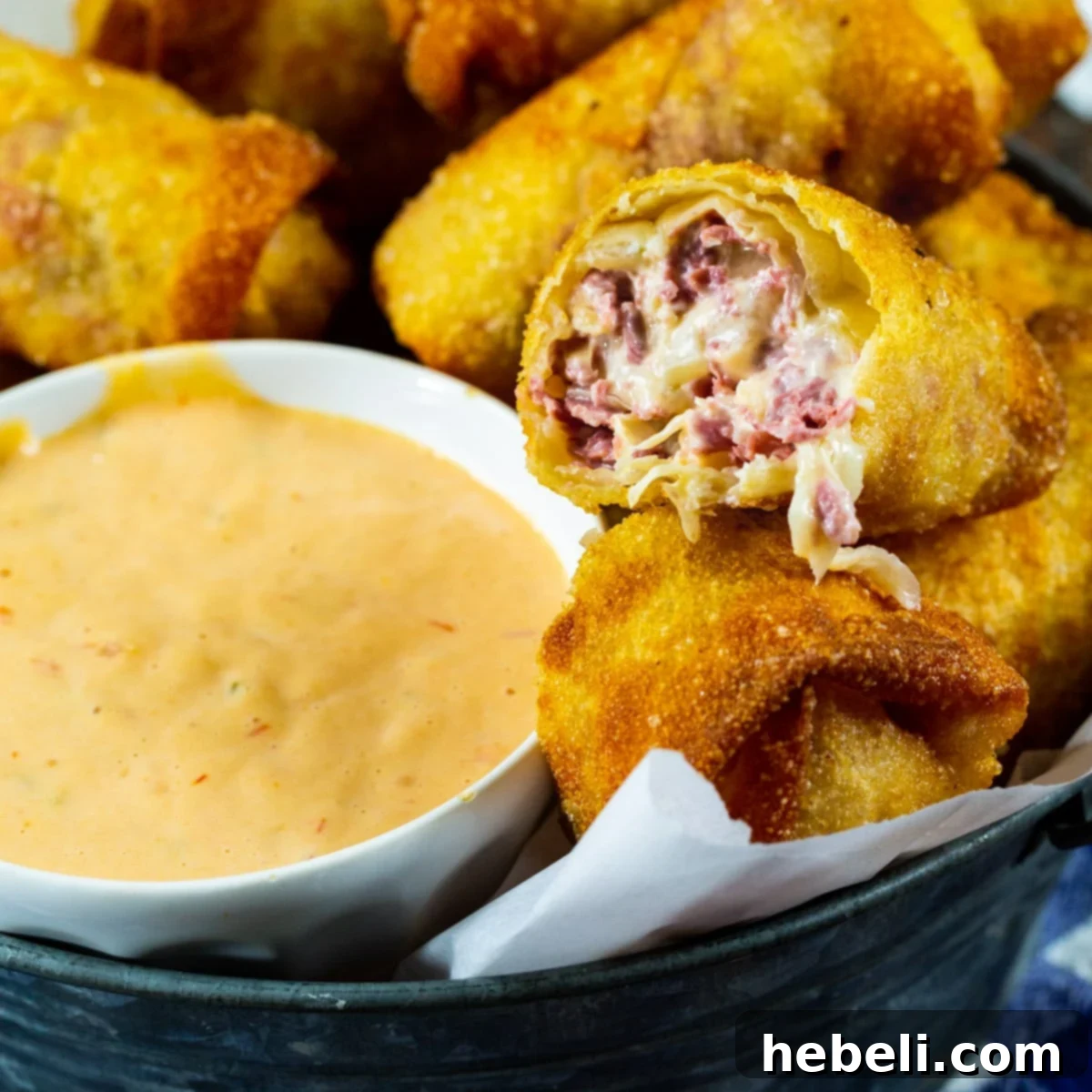 Crispy Reuben Egg Rolls served with a bowl full of Thousand Island Dressing, ready to be enjoyed as a perfect party appetizer.