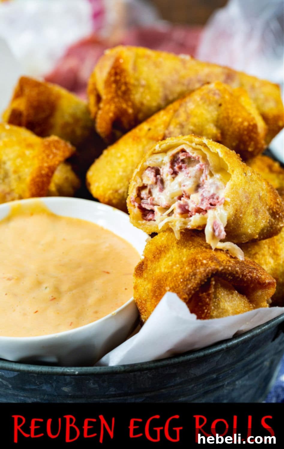 Close-up of freshly made Reuben Egg Rolls filled with corned beef, sauerkraut, and Swiss cheese, served on a rustic wooden board.