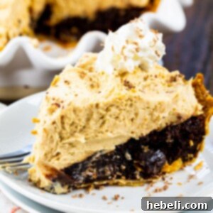 A vibrant, delicious slice of Peanut Butter Mousse Brownie Pie on a plate, ready to be served, displaying its beautifully layered texture.