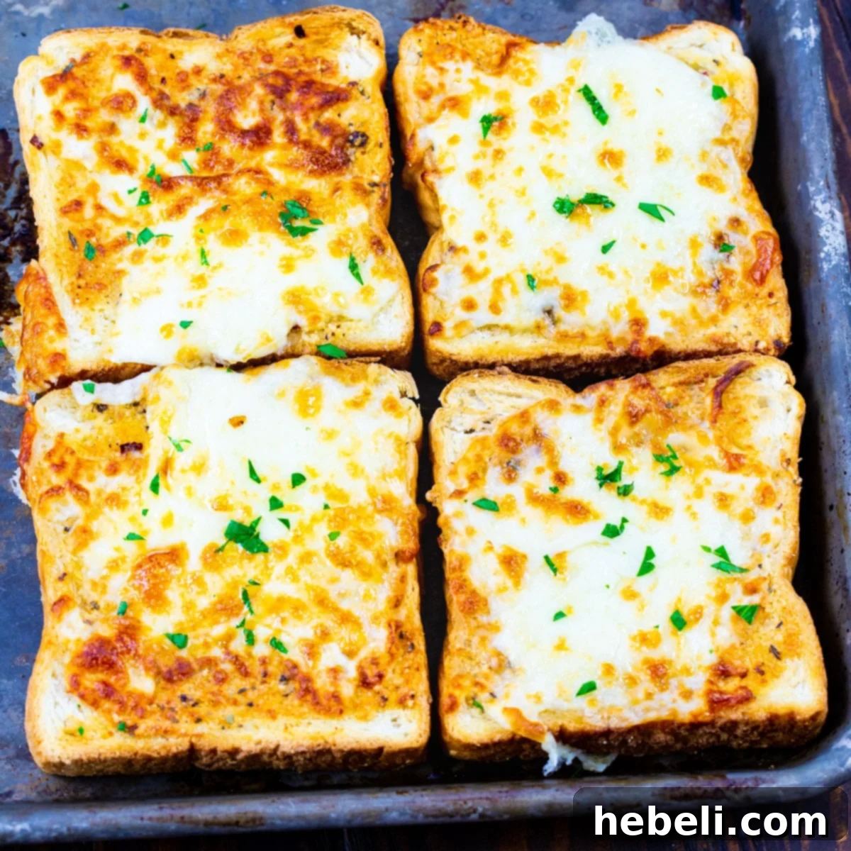 Four Slices of Air Fryer Cheesy Texas Toast, golden brown and melted with cheese.