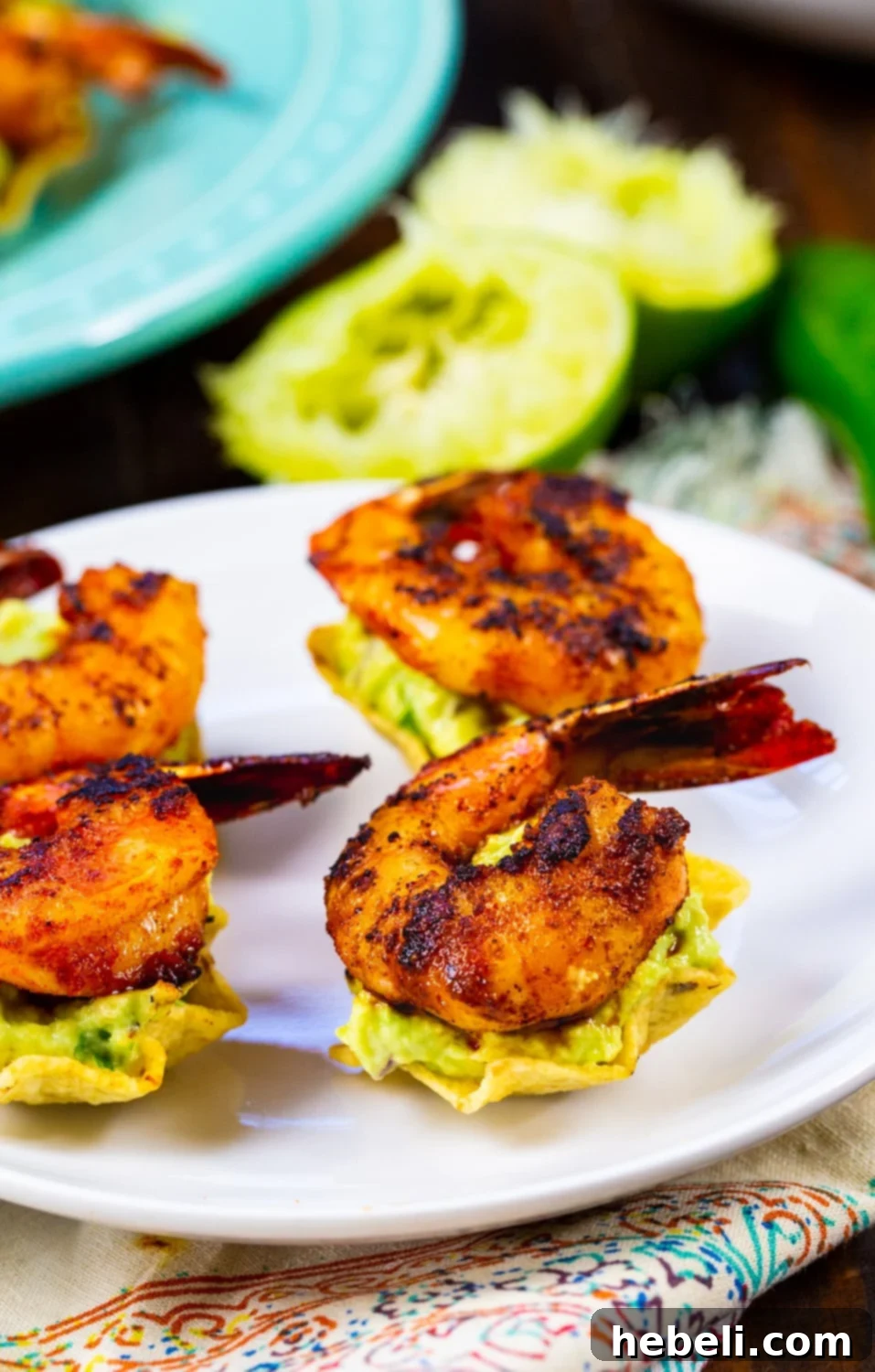 Shrimp Tostada Bites artfully arranged, topped with vibrant green guacamole and perfectly cooked shrimp.
