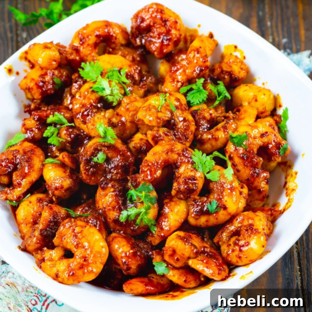 A vibrant bowl filled to the brim with perfectly cooked, fiery Chile and Garlic Shrimp, garnished with fresh cilantro.