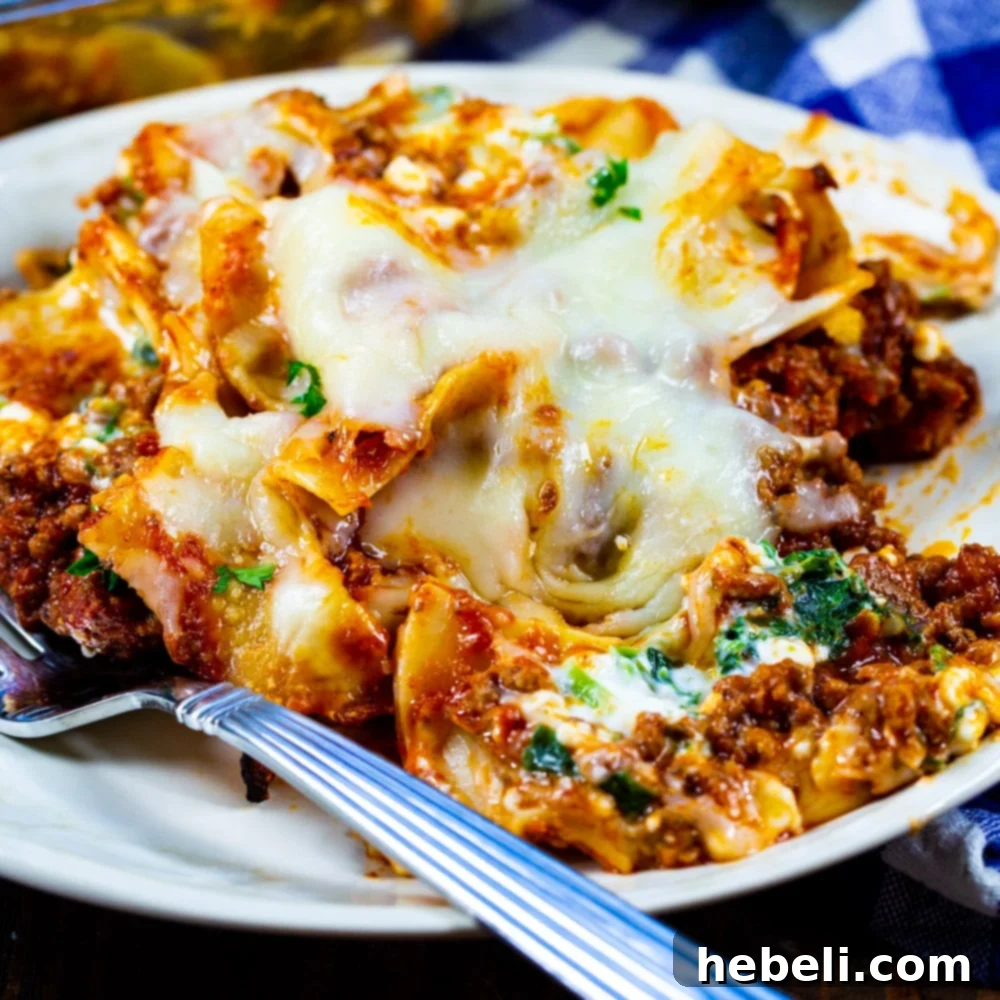 A delicious serving of Beef Florentine Casserole dished up on a white plate, showcasing layers of noodles, meat sauce, spinach, and melted cheese, garnished with fresh parsley.