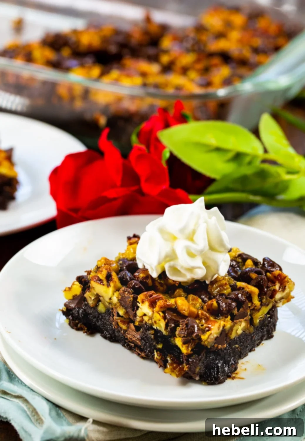 Best Bars for Kentucky Derby Day 3 A single Kentucky Derby Bar, elegantly topped with whipped cream, displayed on a plate with red roses.