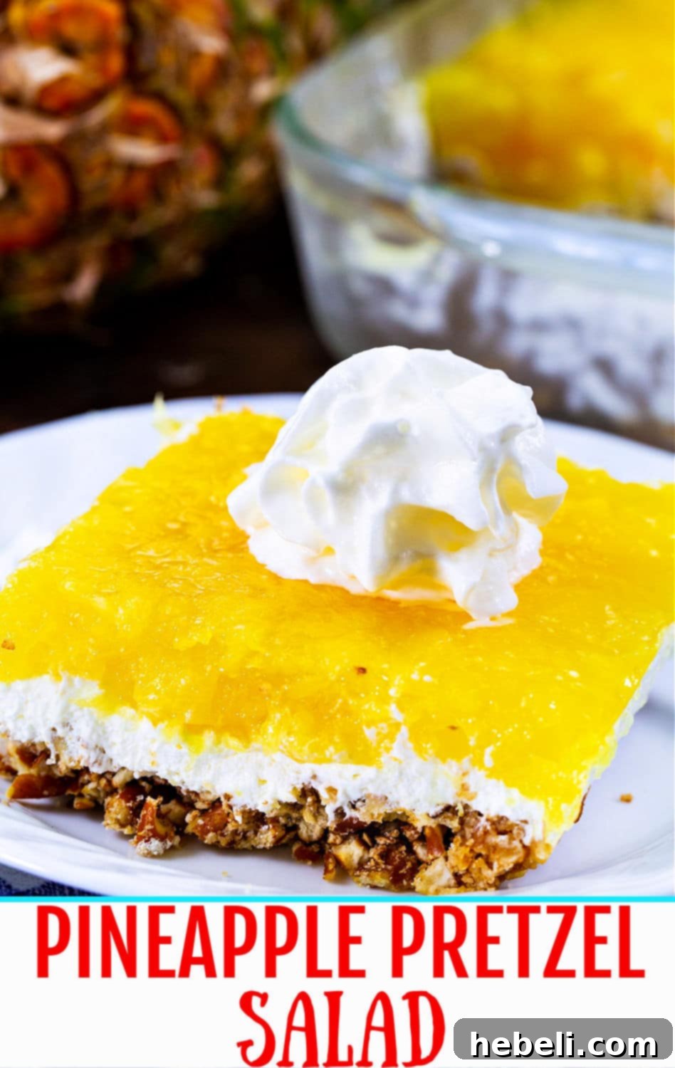 A beautifully presented slice of Pineapple Pretzel Salad, highlighting its vibrant color and layered texture.