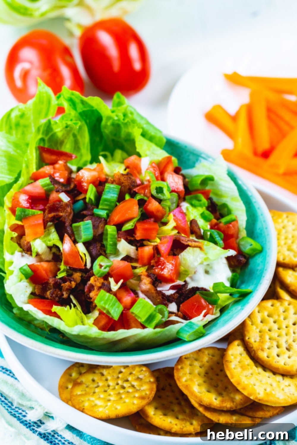 Creamy BLT Dip 4 Close-up of creamy BLT Dip generously topped with vibrant shredded lettuce, diced red tomatoes, and savory crumbled bacon.