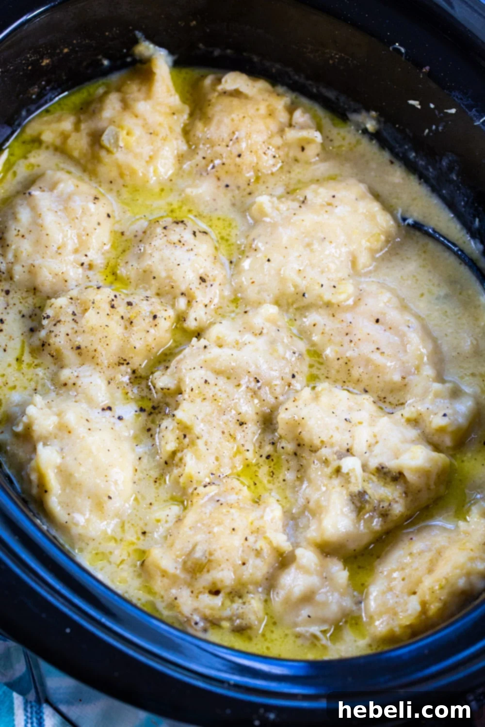 Homestyle Slow Cooker Chicken and Bisquick Dumplings 3 Close-up of chicken and dumplings in a slow cooker, showcasing the creamy sauce and tender ingredients.