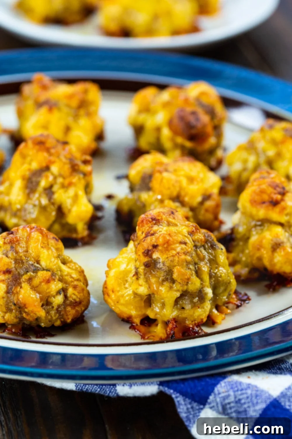 A close-up of a plate filled with golden brown Sausage Balls, highlighting their inviting texture and easy-to-grab size.