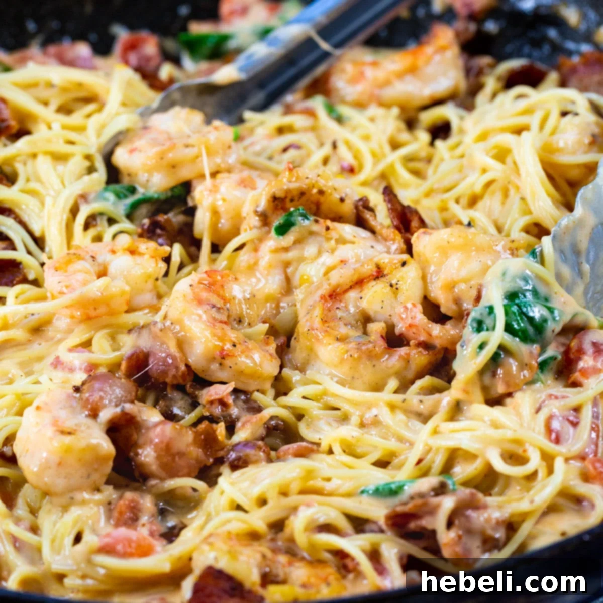 A close-up shot of Creamy Angel Hair Pasta with Bacon and Shrimp, showcasing the rich sauce and perfectly cooked ingredients.