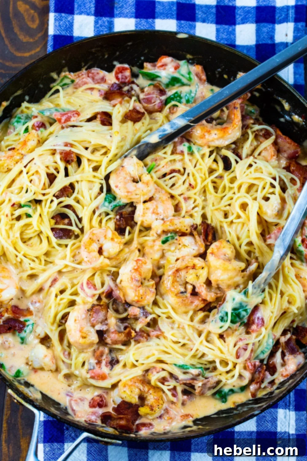 A large skillet filled with the finished Creamy Angel Hair Pasta with Bacon and Shrimp, ready to be served.