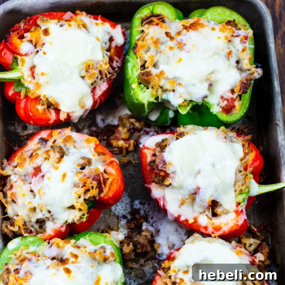 Italian Sausage Stuffed Peppers on a baking sheet, golden and bubbly.