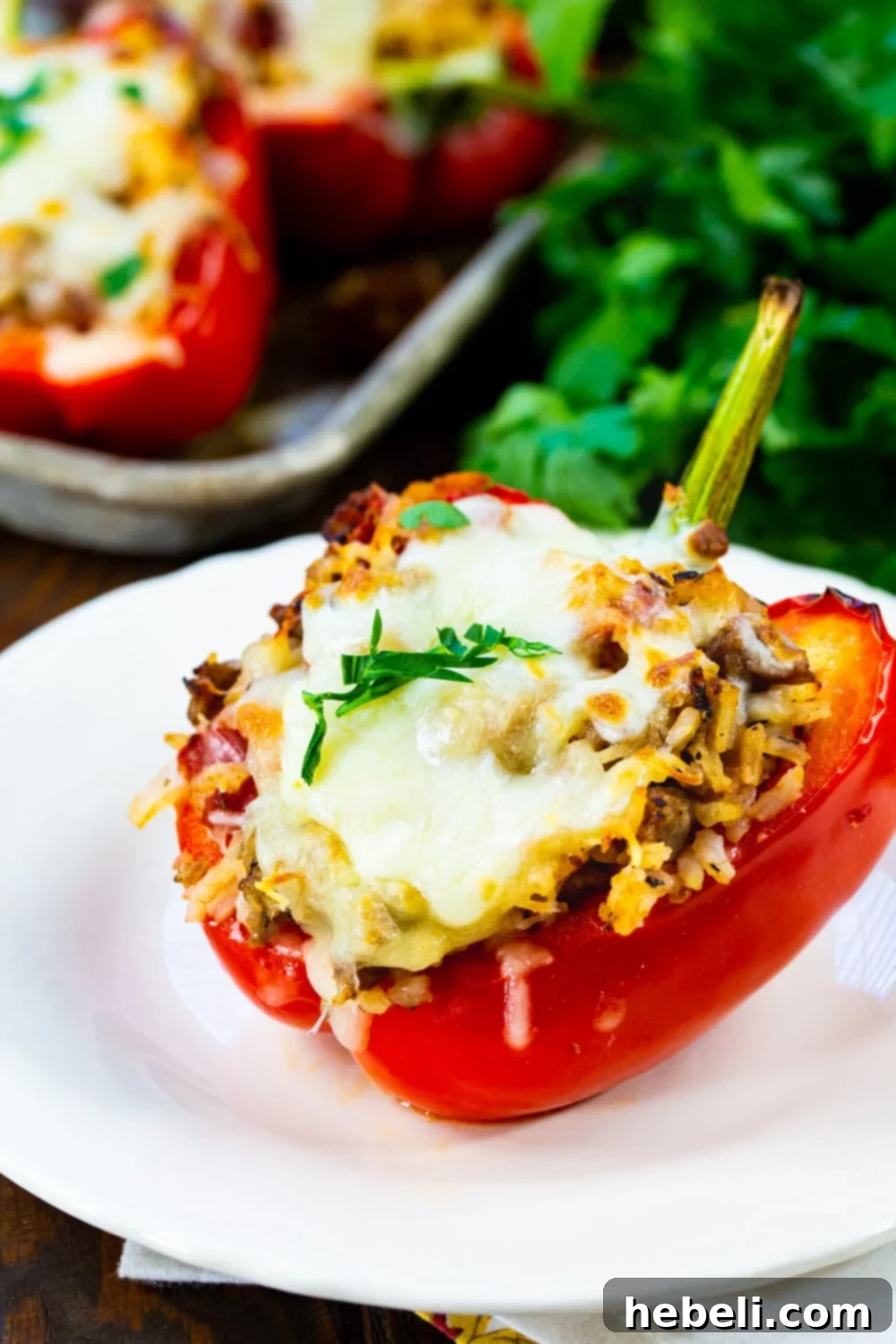 One Italian Sausage Stuffed Pepper on a plate, garnished with parsley.