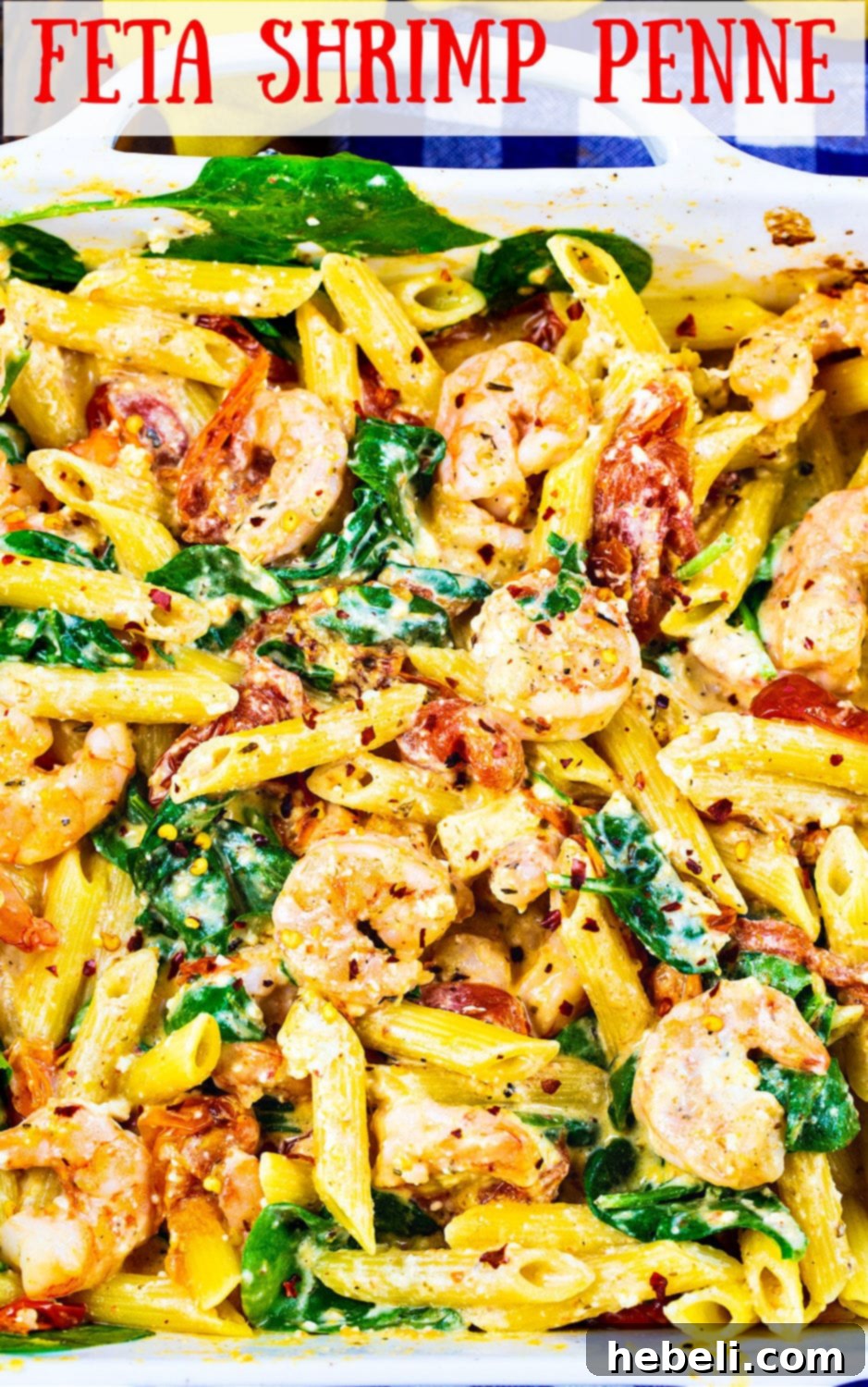 Close-up of a perfectly plated serving of Feta Shrimp Penne on a white plate, garnished with fresh basil, showcasing the rich sauce and tender shrimp.