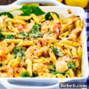 A top-down view of Feta Shrimp Penne pasta dish in a white square baking dish, garnished with fresh parsley.