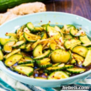 A final presentation of Ginger Sesame Cucumbers in a rustic blue bowl, perfectly chilled and ready to serve.