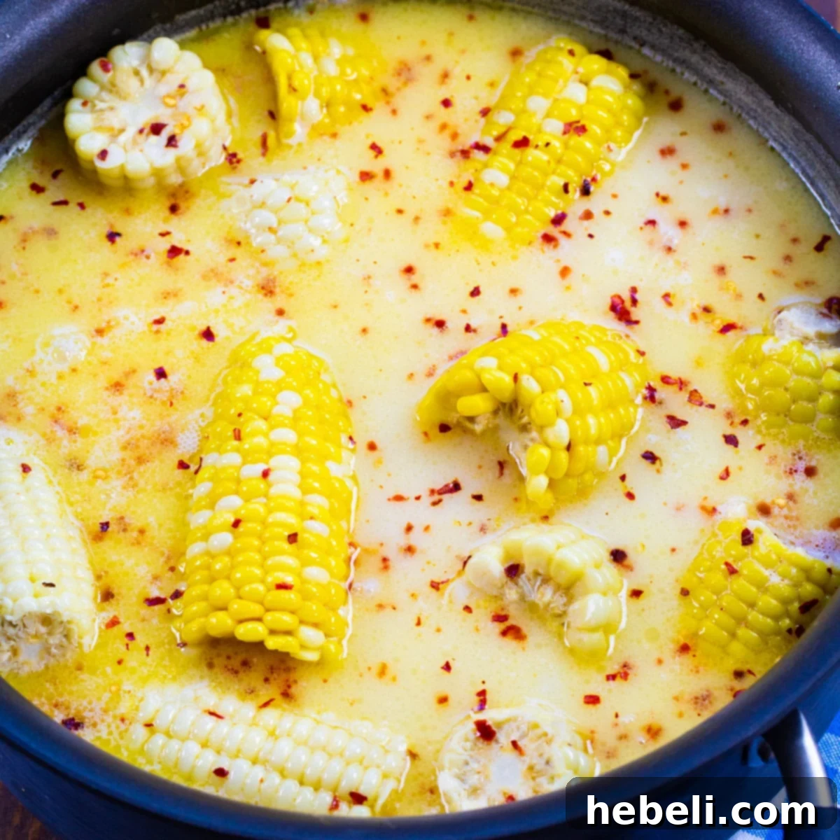 Southern Hot Honey Butter Corn in a large pot with milk, butter mixture simmering