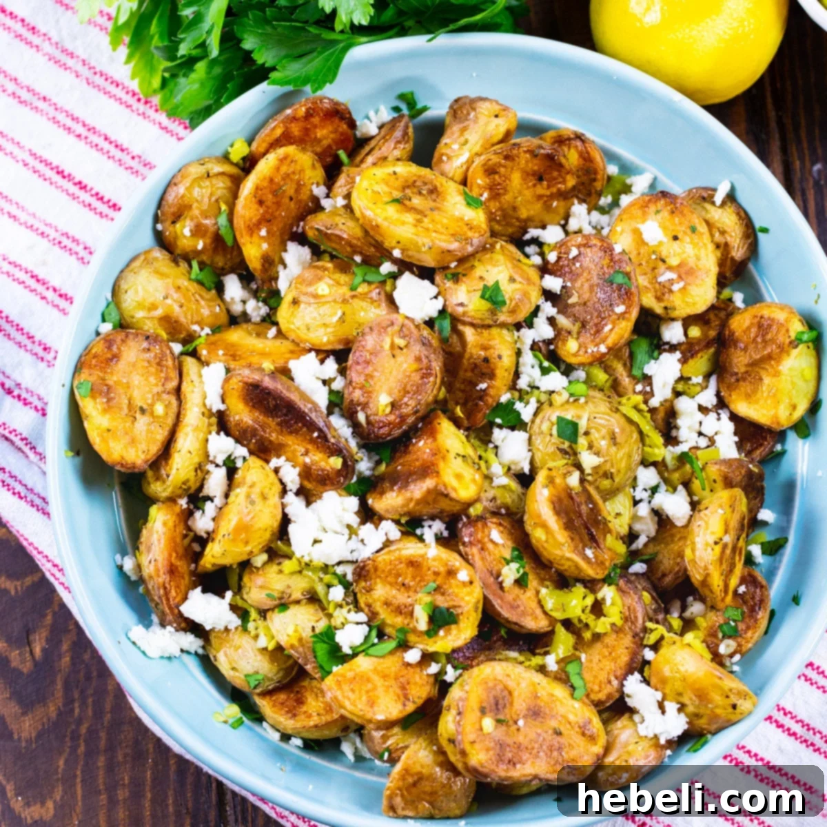 Classic Greek Lemon Potatoes 2 A vibrant bowl of roasted Greek Potatoes, seasoned with fresh oregano, lemon zest, garlic, and crumbled feta cheese, ready to be served.
