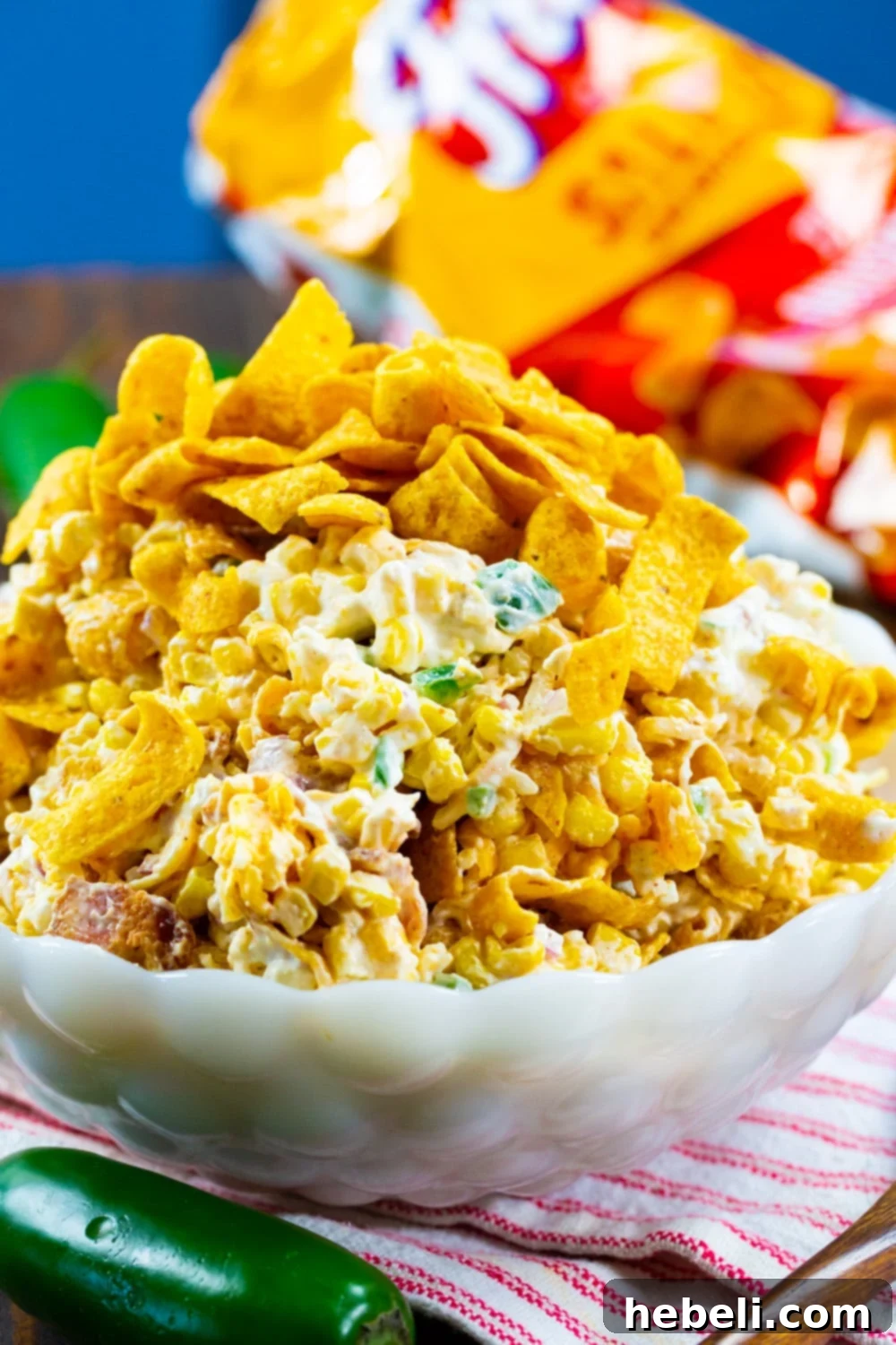 Creamy Jalapeno Frito Corn Salad 3 Close-up of Corn Frito Salad in a white bowl, ready to be served, highlighting the texture of the Fritos.